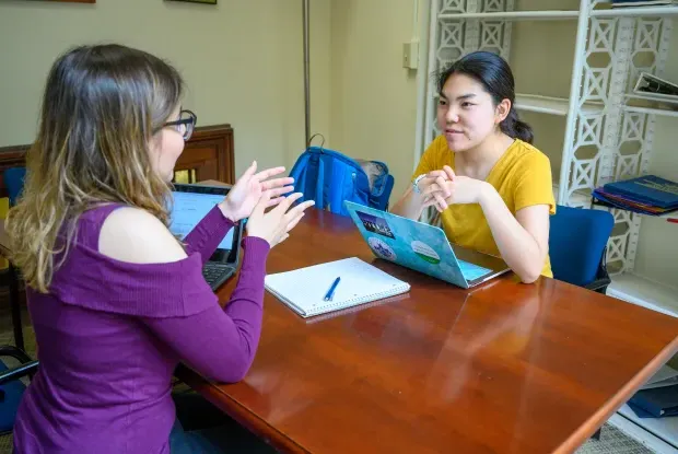 A student and writing tutor discussing a paper.